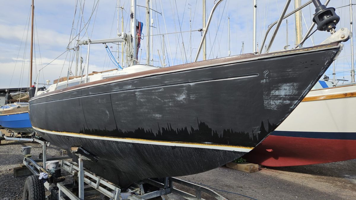 Black Bess before work: dull, scratched black topsides with chalky patches and runs