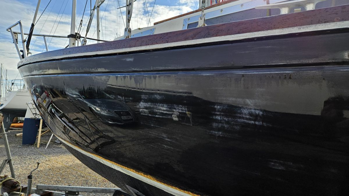 Close view along Black Bess's topsides as the gloss coats go on