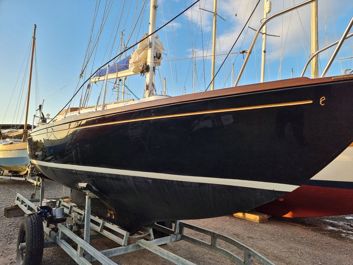 Black Bess finished: deep gloss black topsides with a gilded cove line and fresh cream boot-top