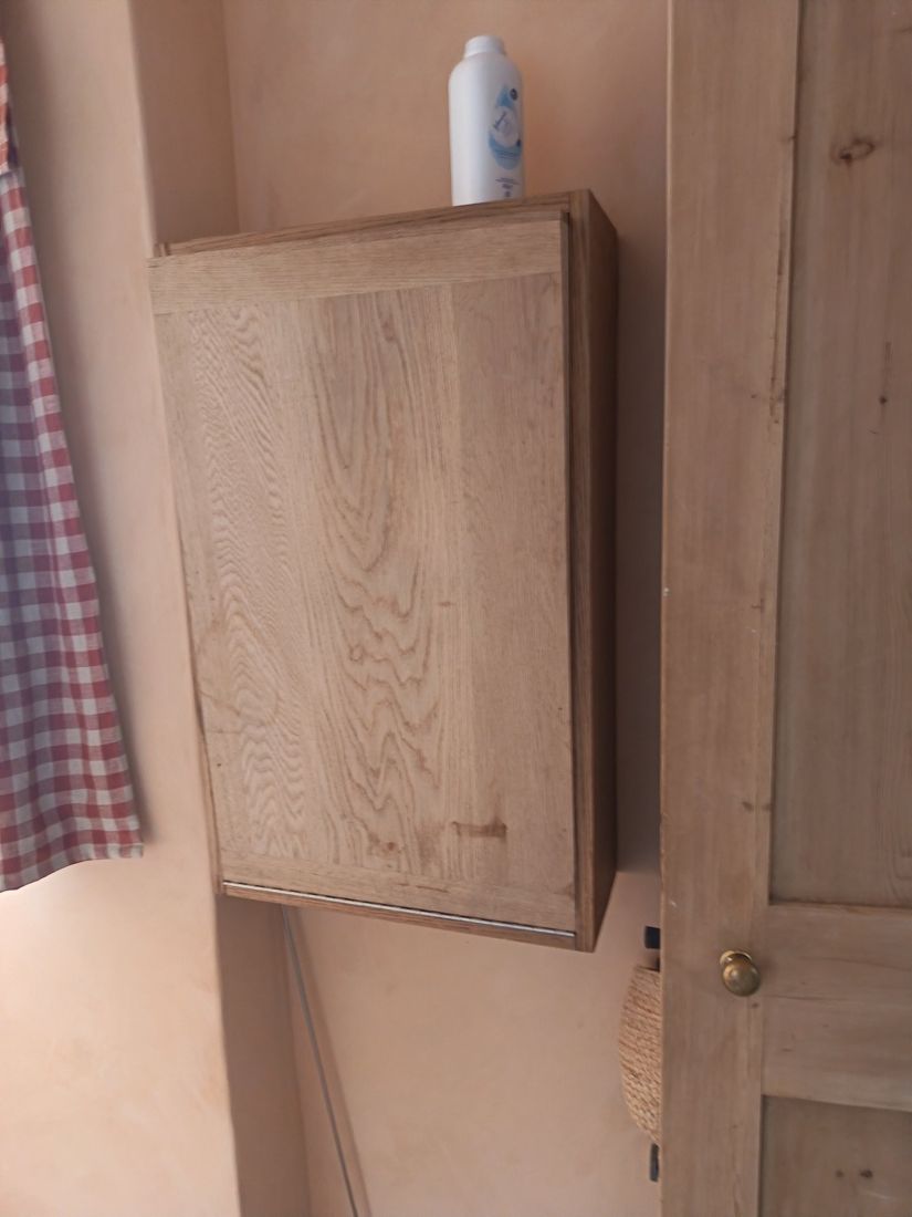 Oak wall cabinet closed flat against the nursery wall