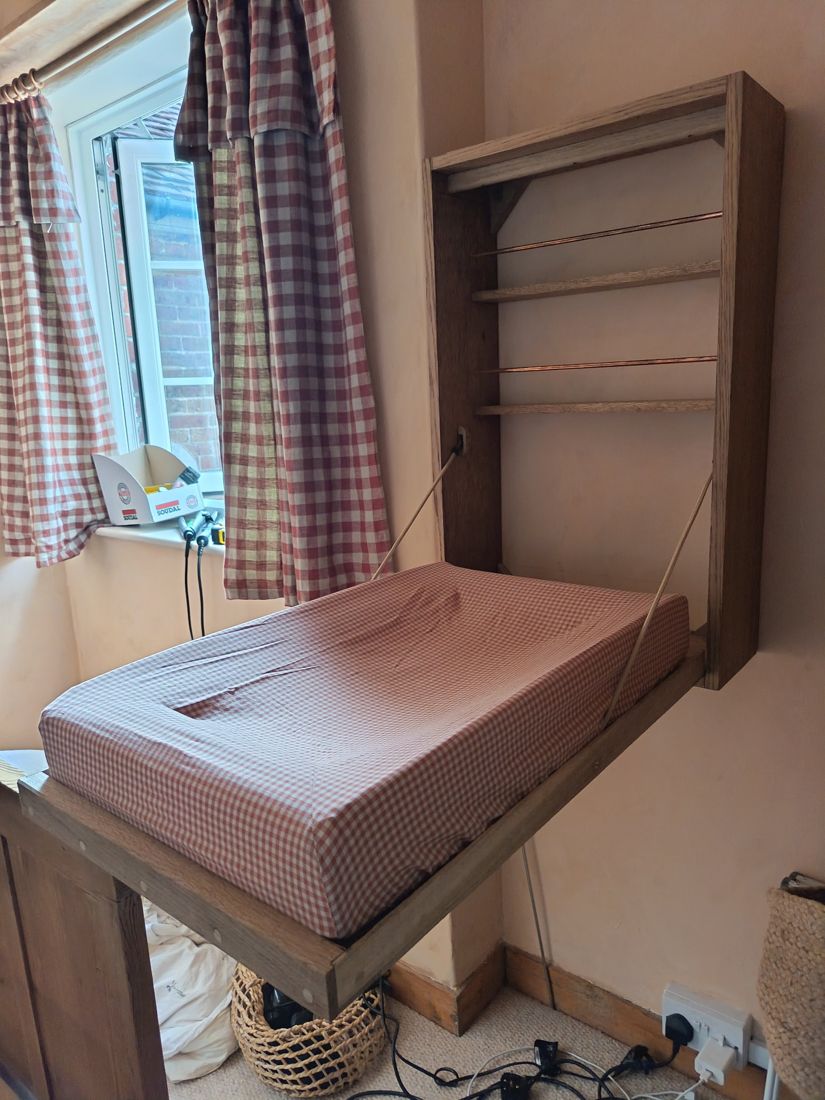 The cabinet folded down into a changing table on two lines, showing shelves and copper rails inside