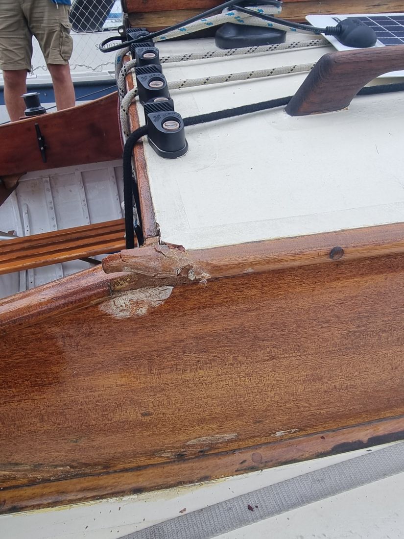 Close view of the split and crushed coaming corner where the cabin side meets the cockpit