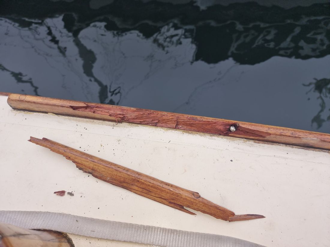 Splintered section of Folkdance's toerail, with the broken piece lying on the side deck