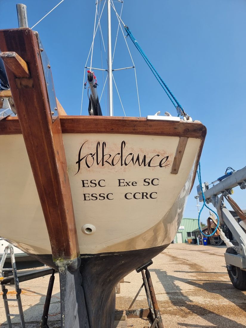 Folkdance's transom with her hand-lettered name and club initials, ashore at the yard