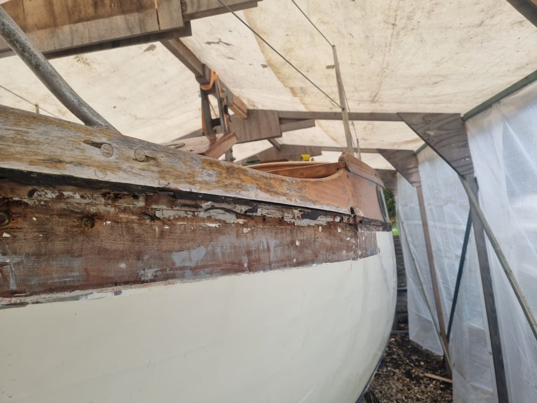 Hightime's weathered covering board lifting away from a rotten, paint-flaked sheer