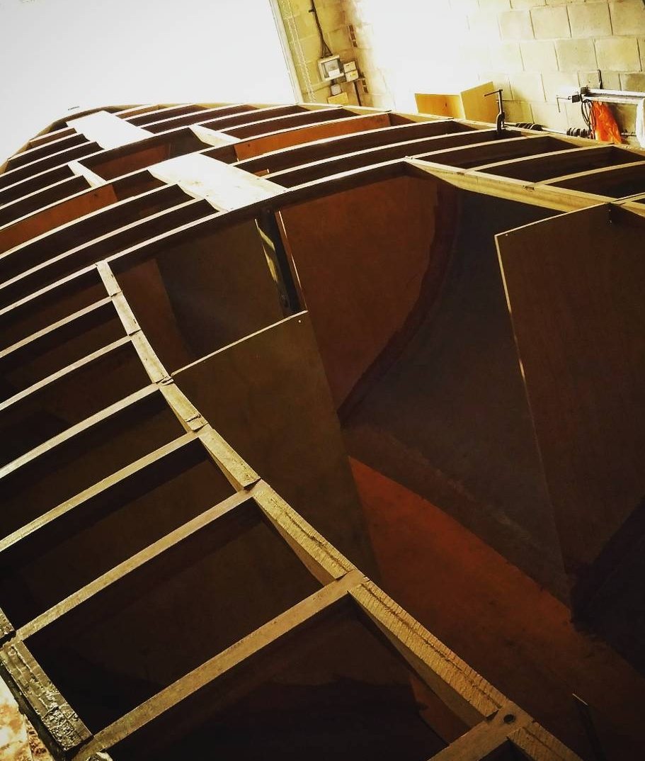 Kattegatt 26 under construction in the workshop: plywood bulkheads and timber framing set up inside the hull