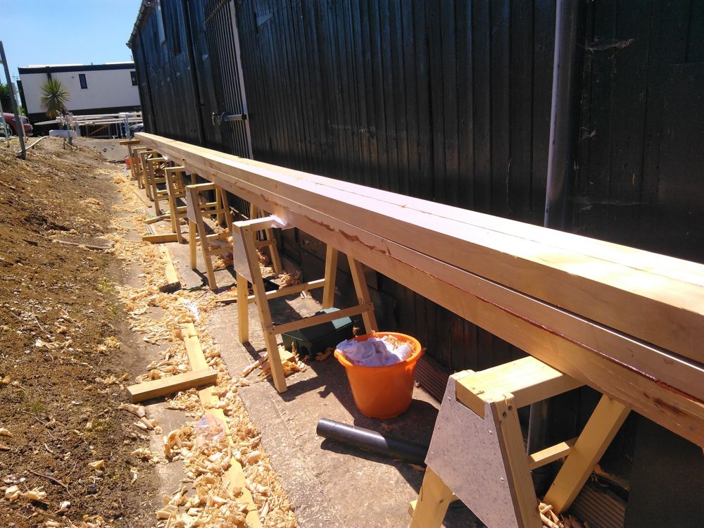 Full-length glued mast blank on trestles, glue lines still visible