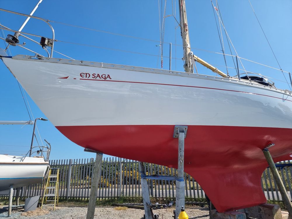 White topsides and fresh red antifouling with the boat's name and sheer line in red