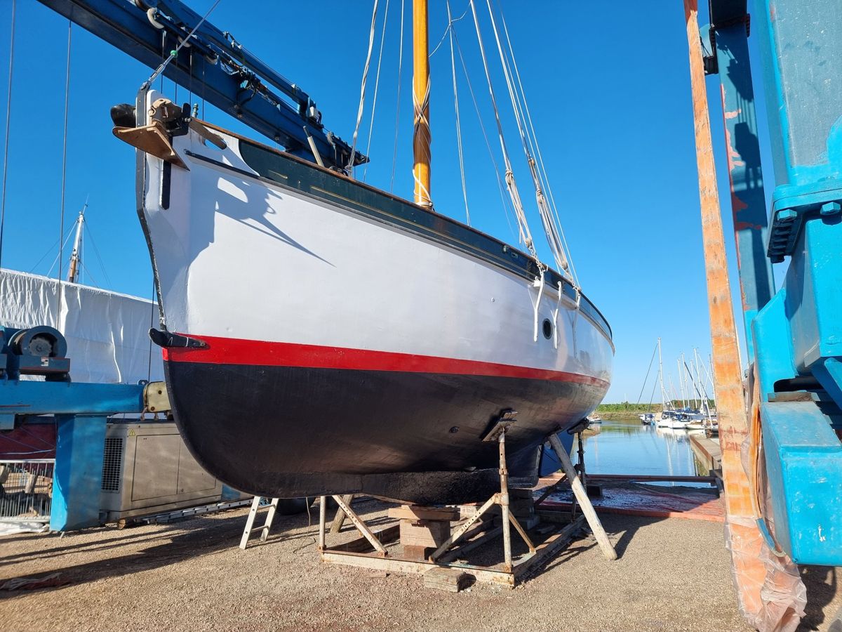 Rhoda after repainting, with fresh white topsides, bright red boot-top and new black bottom paint