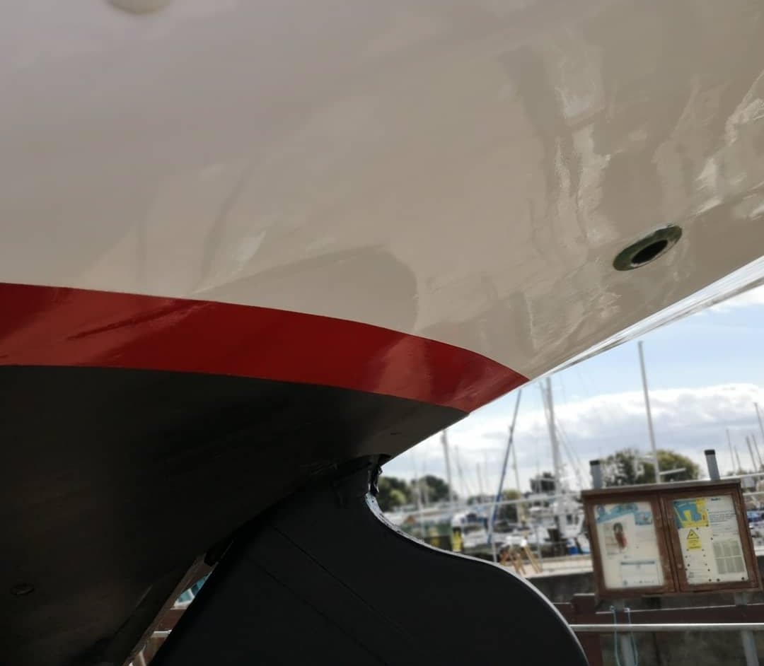Under Rhoda's counter: white gloss topsides, red boot-top and black bottom paint meeting at the rudder