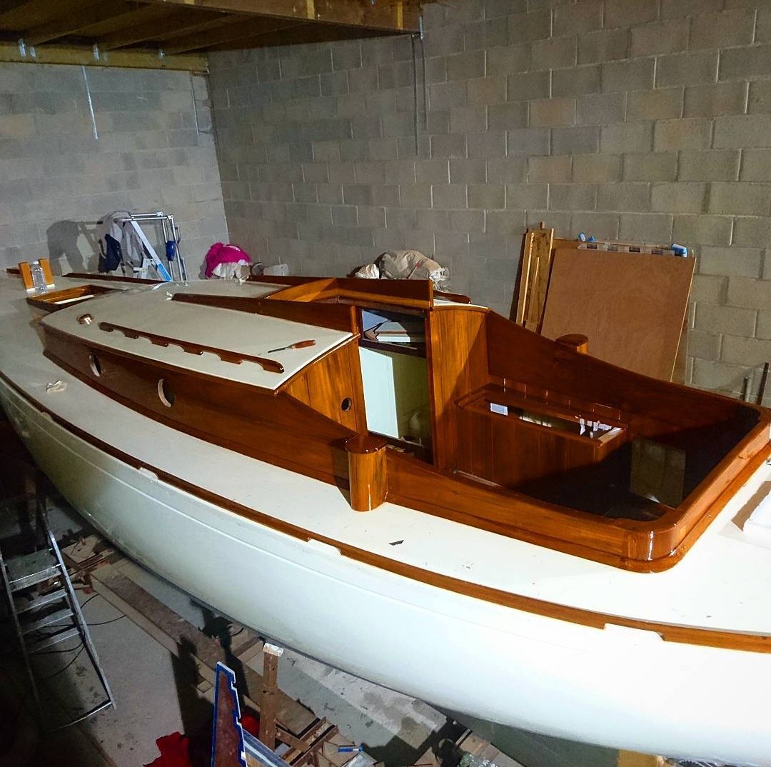 Roamer nearly finished in the workshop: white hull, new varnished coachroof, cockpit coamings and toe rails