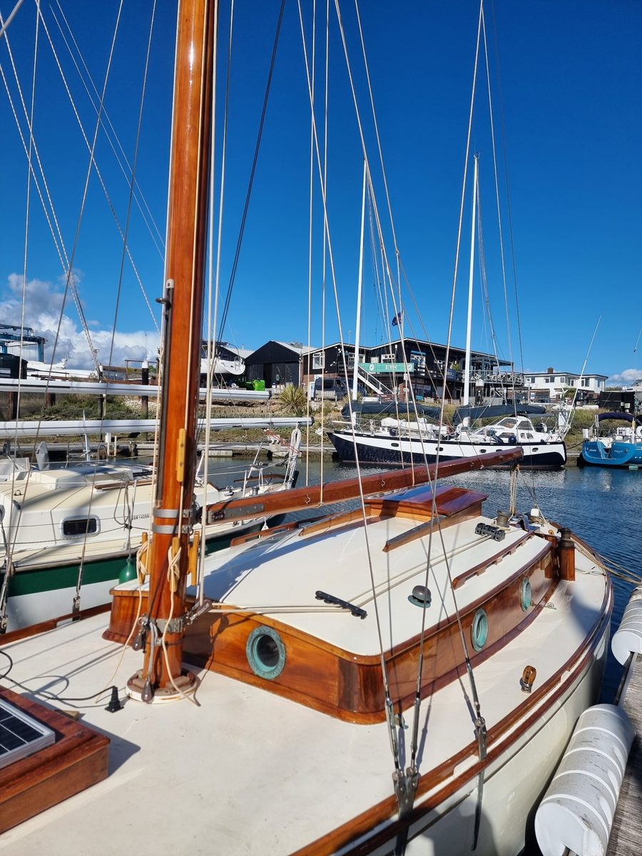 Roamer alongside in Emsworth Yacht Harbour, her varnished Douglas fir mast, boom, coachroof sides and rubbing strake glowing against cream decks