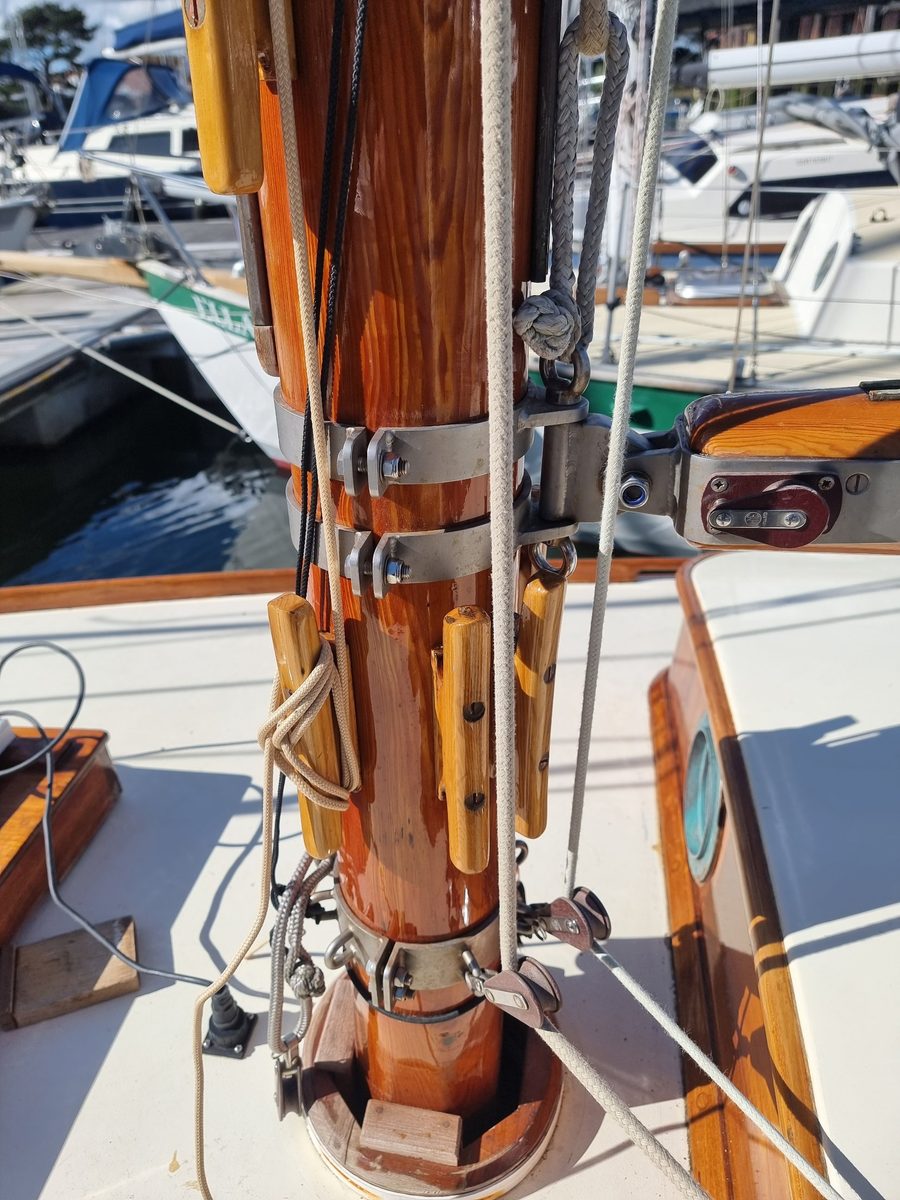 Foot of Roamer's varnished Douglas fir mast with ash cleats, stainless mast bands and the gooseneck