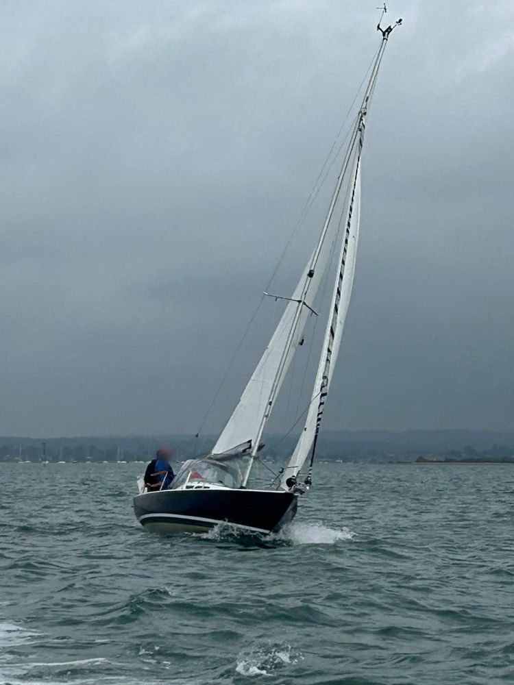 Sempre en Giro heeled hard under sail on a grey, breezy day