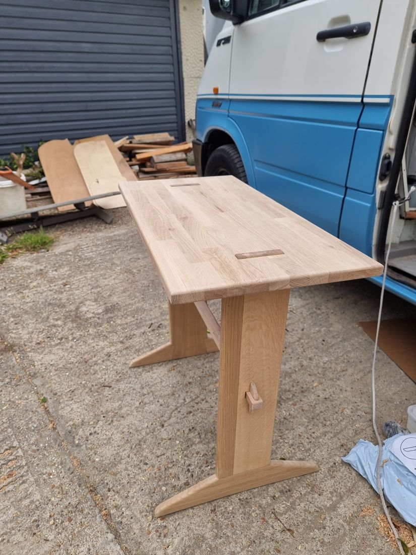 Freestanding oak table with trestle legs and a wedged through-tenon, before finishing