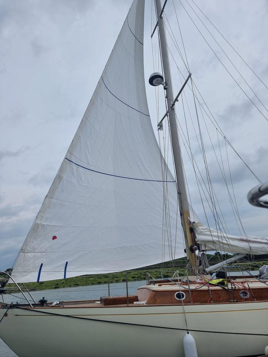Zircon alongside with her genoa hoisted, varnished coachroof and cream hull below