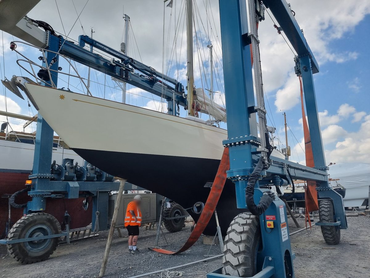 Zircon in the travel hoist slings, cream topsides with a gold cove line and star, fresh black antifouling below